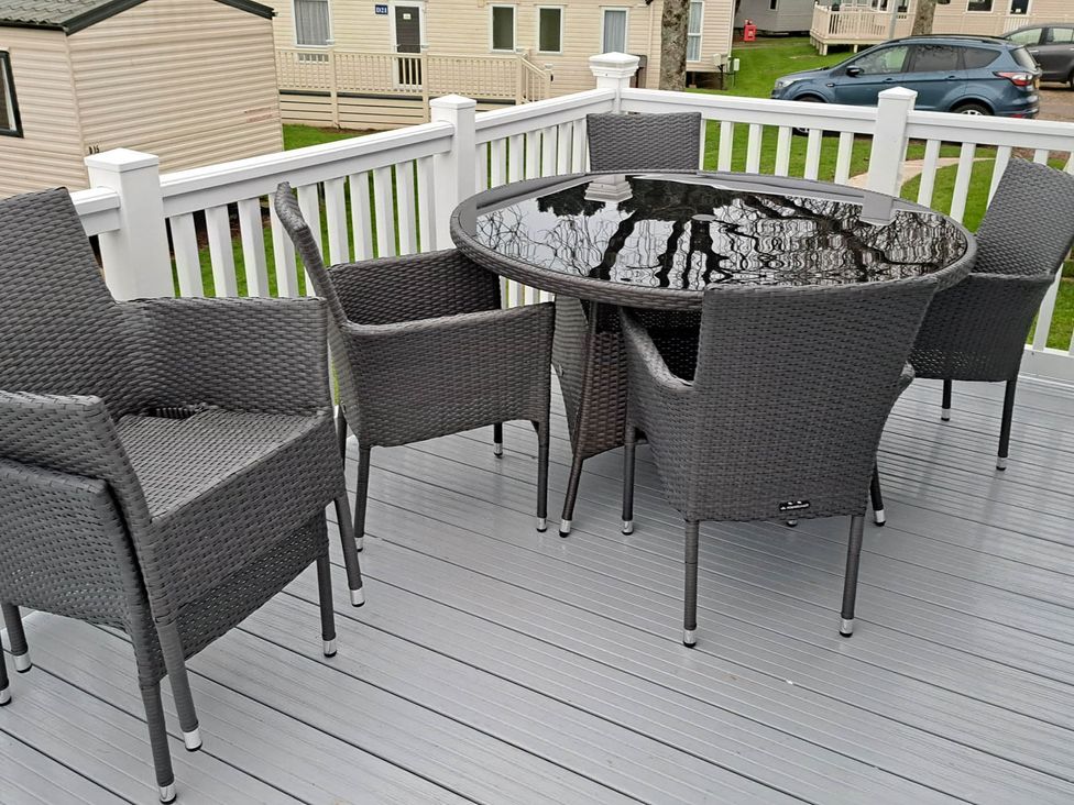 A table and chairs on the patio at Tranquil Lodge Retreat in Paignton