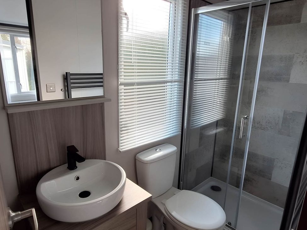 A bathroom with a sink, toilet, and shower stall at Tranquil Lodge Retreat in Paignton