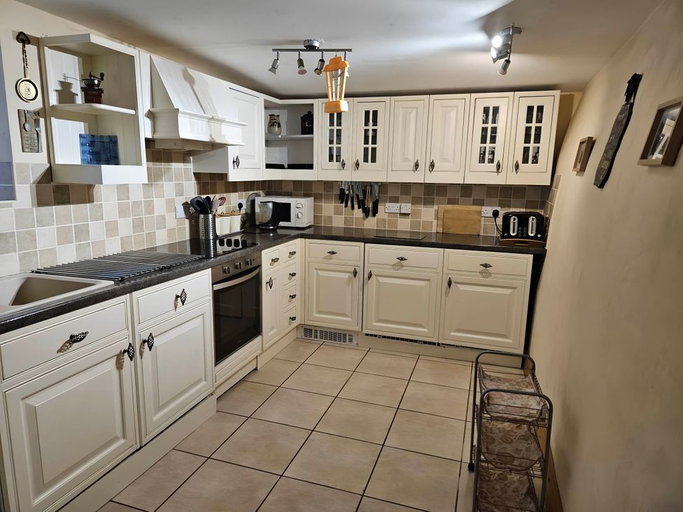 A kitchen with cabinets, sink, oven, and countertop at Rose Cottage - Cosy cottage in Millers Dale