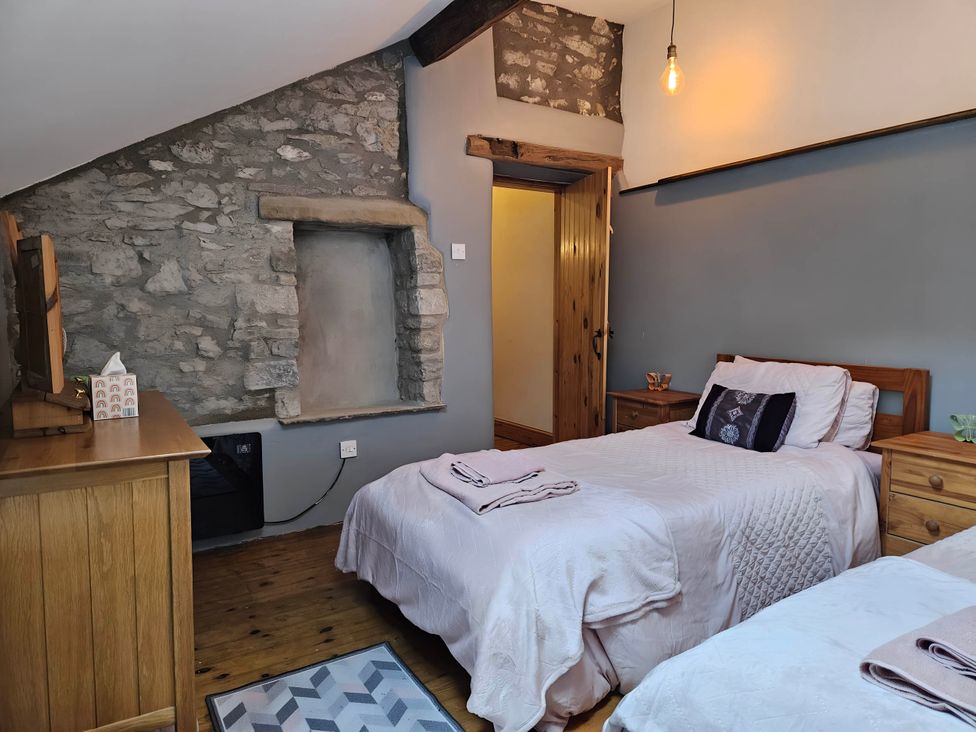 A bedroom with two beds and a television at Rose Cottage - Cosy cottage in Millers Dale