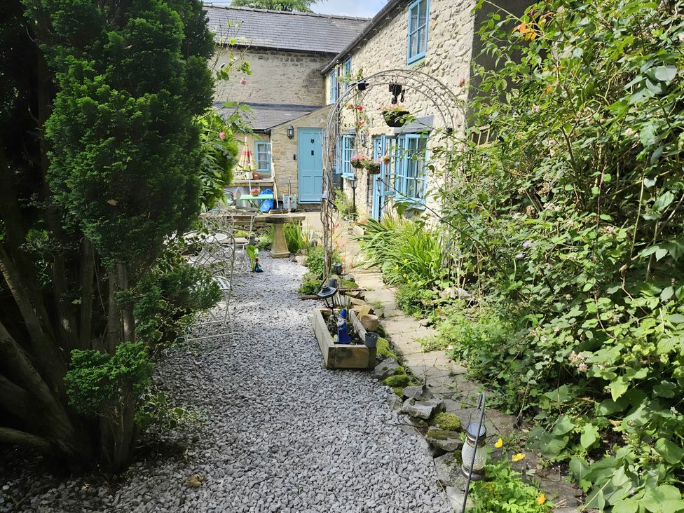 A garden with a gravel path leading to a blue door at Rose Cottage - Cosy cottage in Millers Dale Chapel-En-Le-Frith