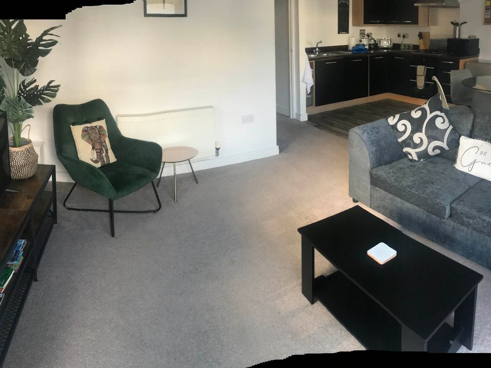 A living room with a sofa and an armchair at 2-Bed Apartment Sleeps 4 with Garden