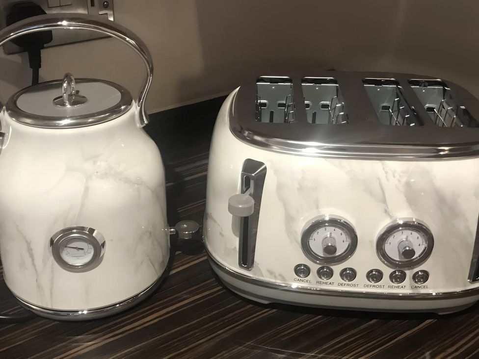 A kettle and toaster on a countertop in a kitchen