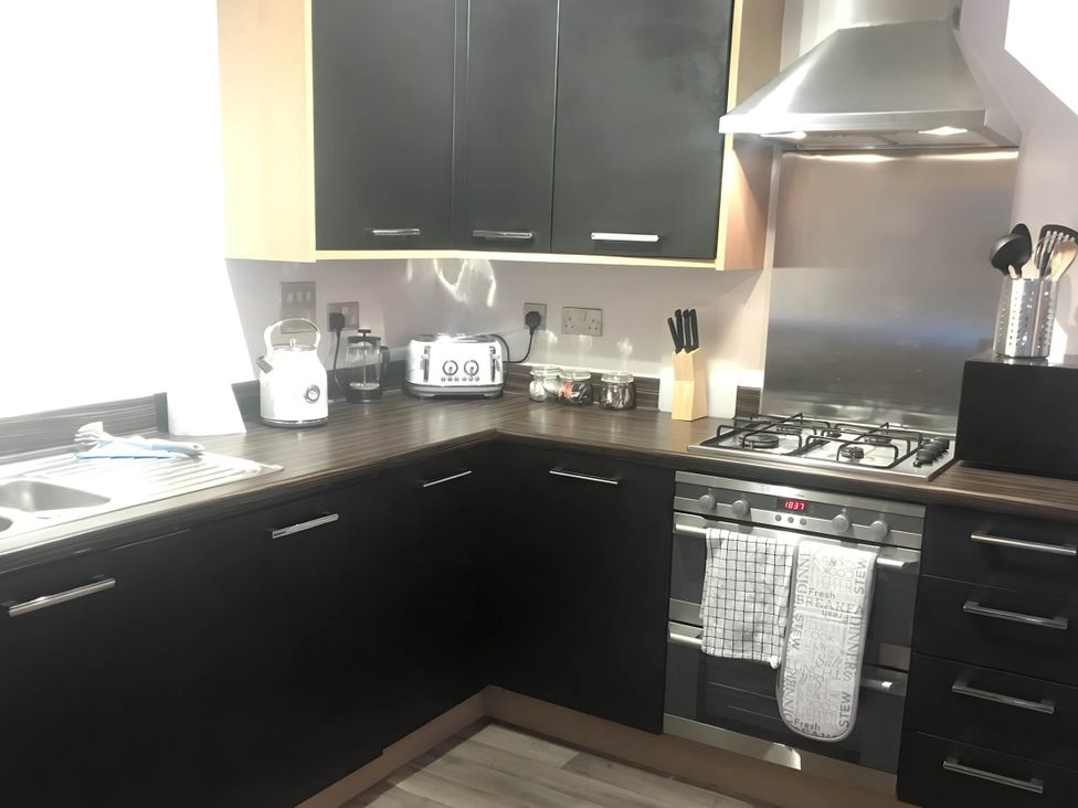 A kitchen with appliances on countertop at 2-Bed Apartment Sleeps 4 with Garden