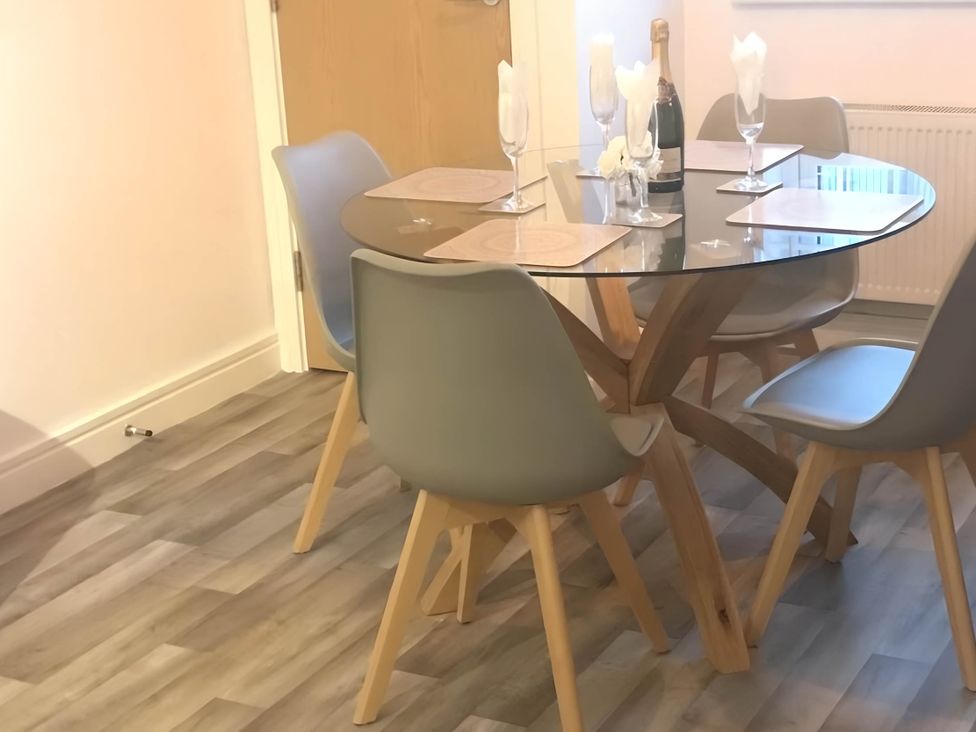 A dining room with a glass table and chairs at 2-Bed Apartment Sleeps 4 with Garden