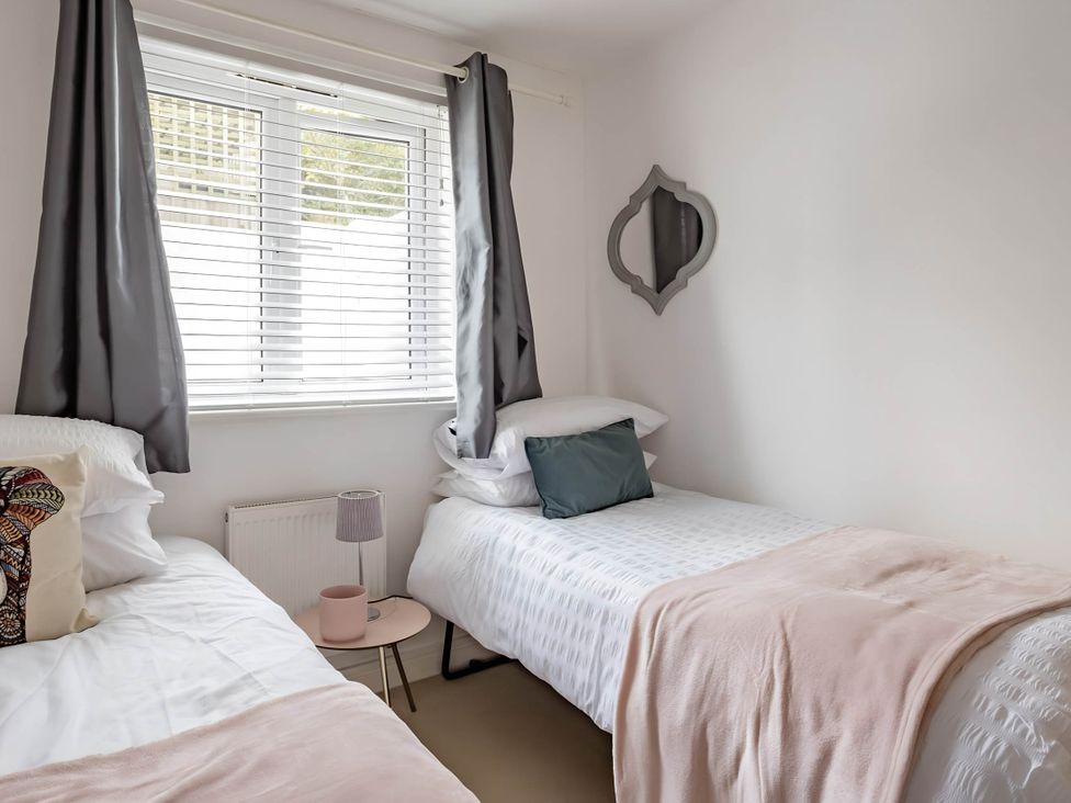 A bedroom with two beds and a window at 2-Bed Apartment Sleeps 4 with Garden