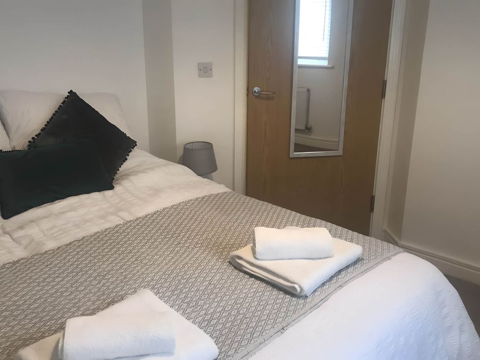 A bedroom with a bed and towels on it at 2-Bed Apartment Sleeps 4 with Garden