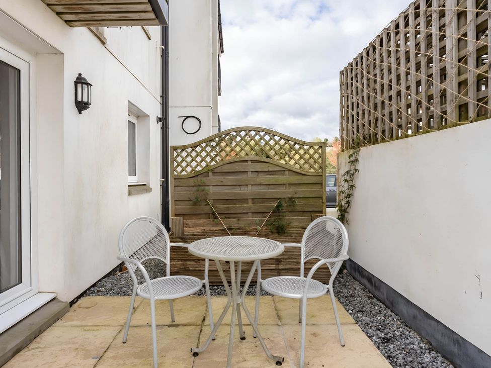 An outdoor area with a table and chairs at 2-Bed Apartment Sleeps 4 with Garden