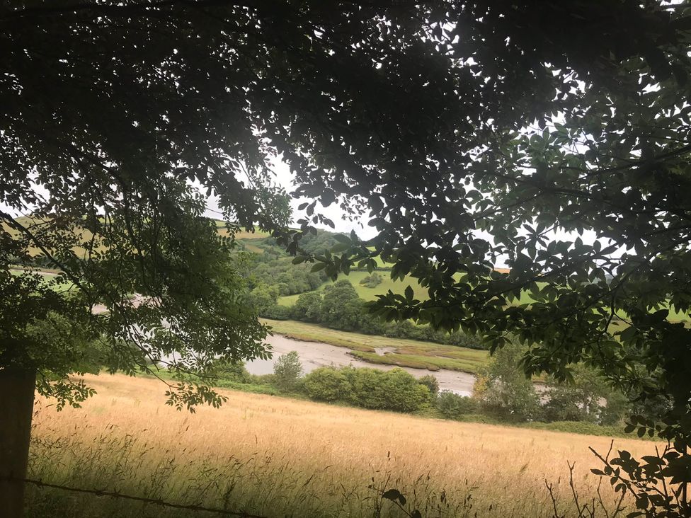 A view of a river and hills surrounded by trees and grass at 2-Bed Apartment Sleeps 4 with Garden