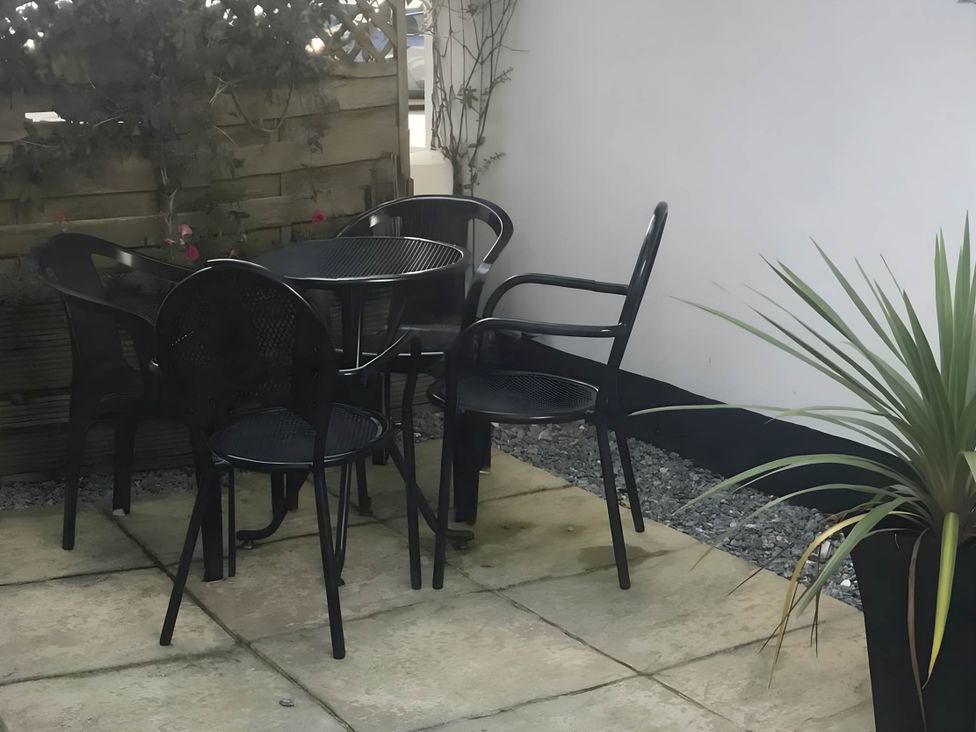 A garden area with a table and chairs at 2-Bed Apartment Sleeps 4 with Garden