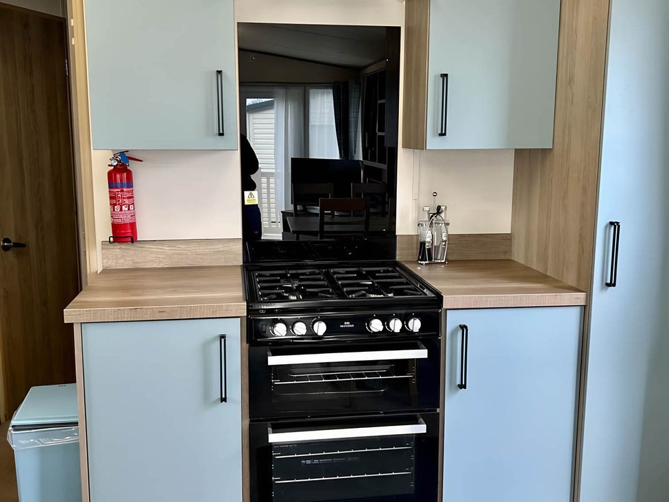 A kitchen with a gas cooker and kitchen cabinets at Beautiful Static Caravan Hoburne Devon Bay