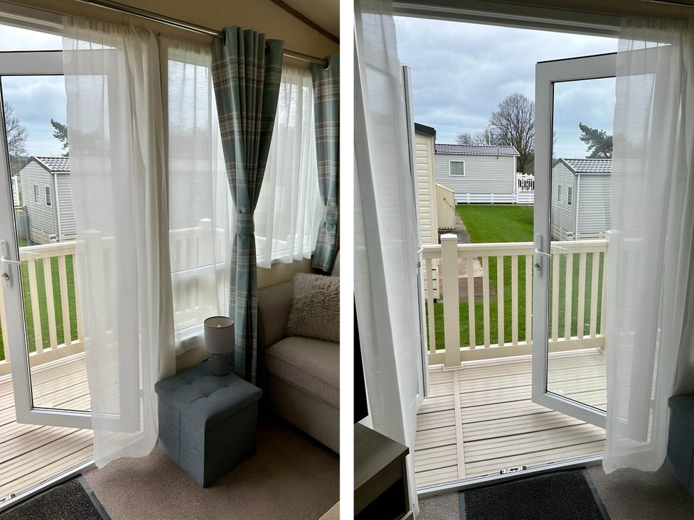 A living room with a sliding door leading to the balcony at Beautiful Static Caravan Hoburne Devon Bay