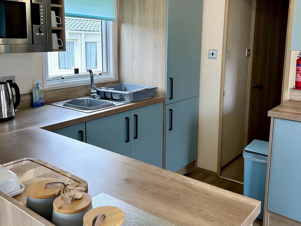 A kitchen with sink and cabinets at Beautiful Static Caravan Hoburne Devon Bay