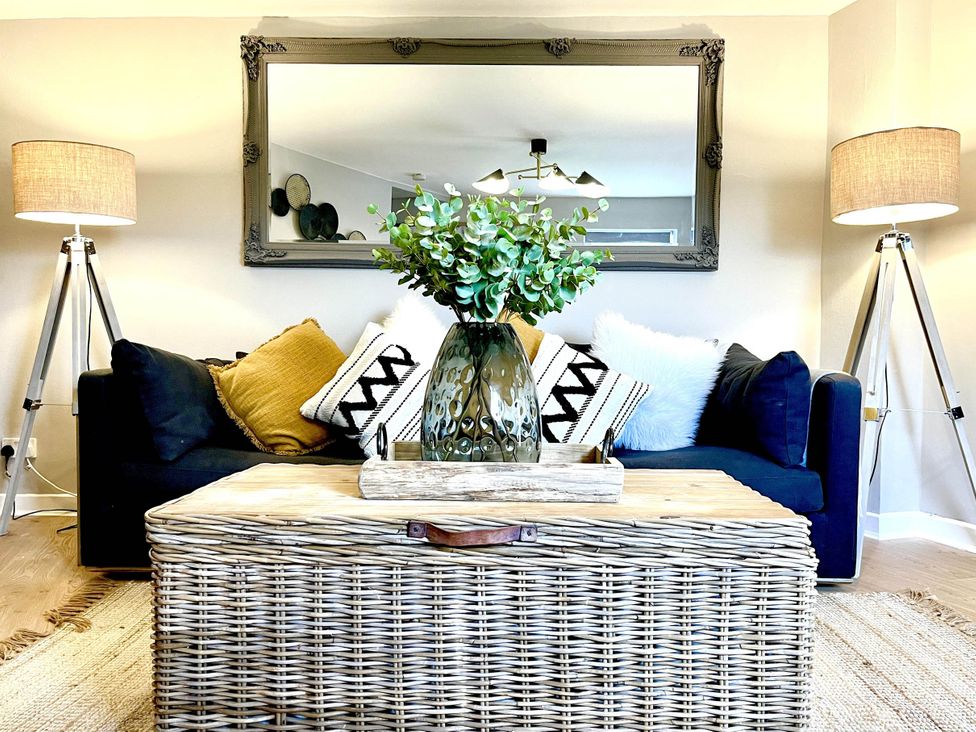 A living room with a sofa, coffee table, floor lamps, and a mirror at Central Ellesmere - Stay 2 - Parking - PetFriendly