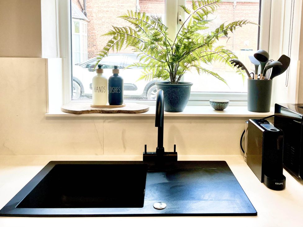 A sink with a tap and plants on a windowsill at Central Ellesmere - Stay 2 - Parking - PetFriendly