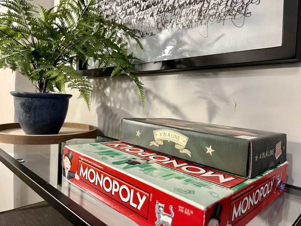 A plant and board games on a table at Central Ellesmere - Stay 2 - Parking - PetFriendly