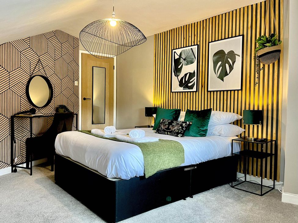 A bedroom with a bed, mirror, and wall art at Central Ellesmere - Stay 2 - Parking - PetFriendly