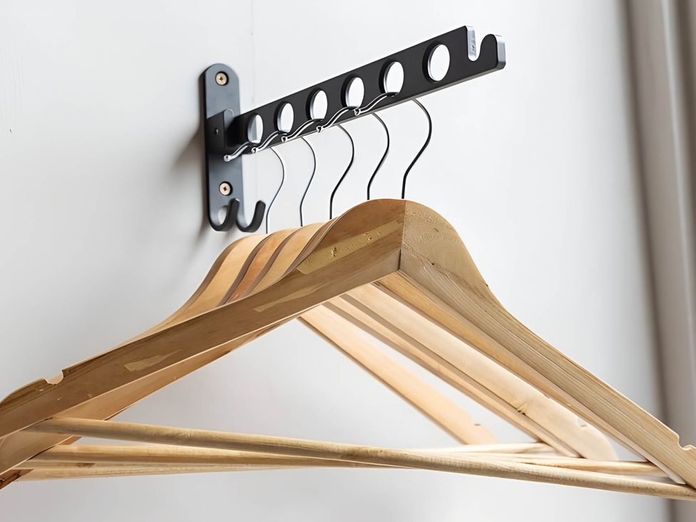 A wooden hanger on a hook rack