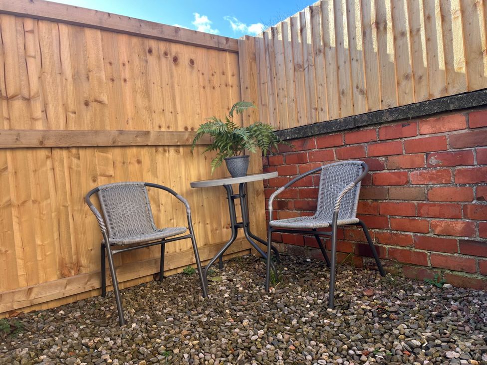 A garden area with chairs and a table at Central Ellesmere - Stay 2 - Parking - PetFriendly 