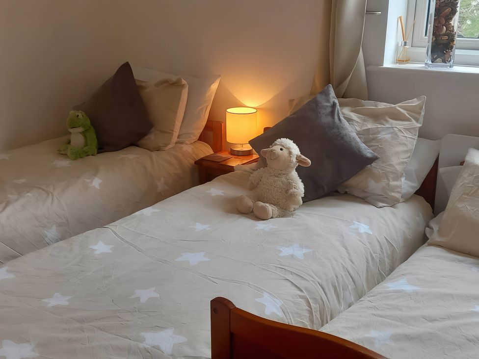 A bedroom with two beds, a lamp, and stuffed animals at 2 Bed House - Sleeps 6 - Pets - Garden - Parking