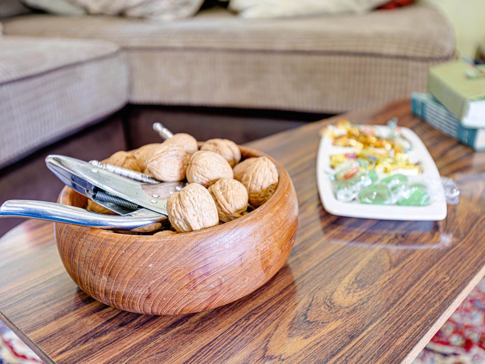 A wooden bowl with walnuts and a nutcracker in a living room at Family Country Cottage with a private Valley View