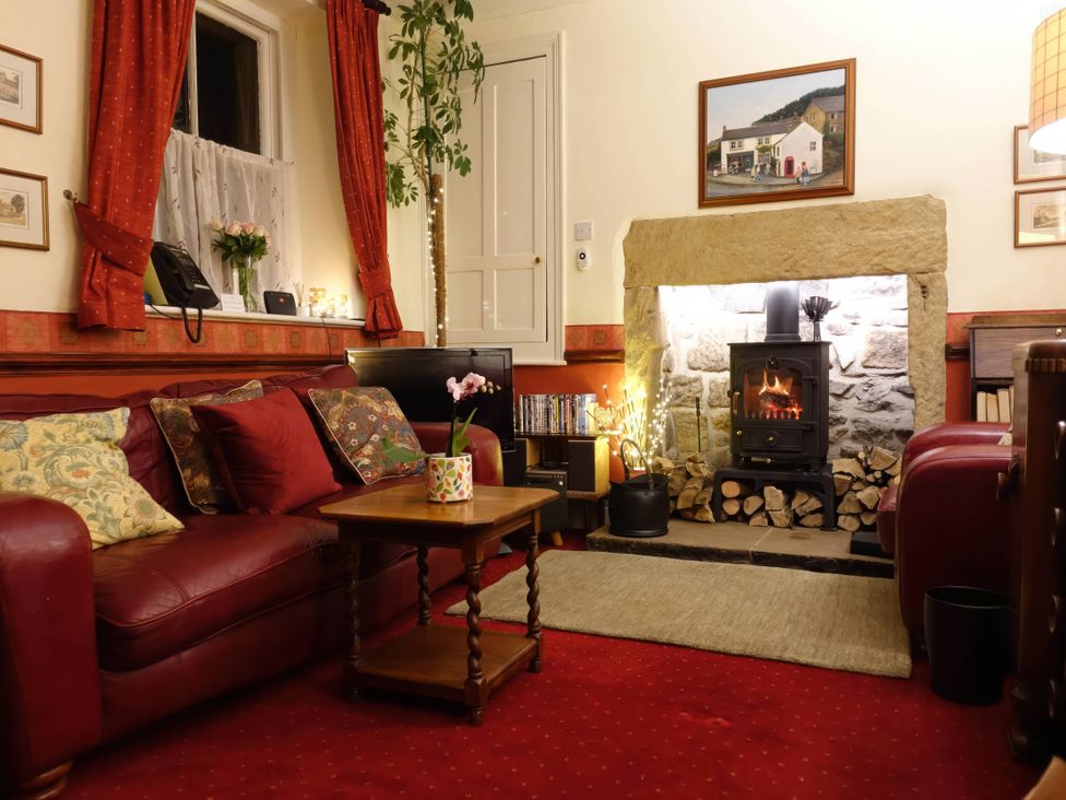 A living room with a sofa and fireplace at Traditional 2 Bedroom Cottage in Eyam, Hope Valley