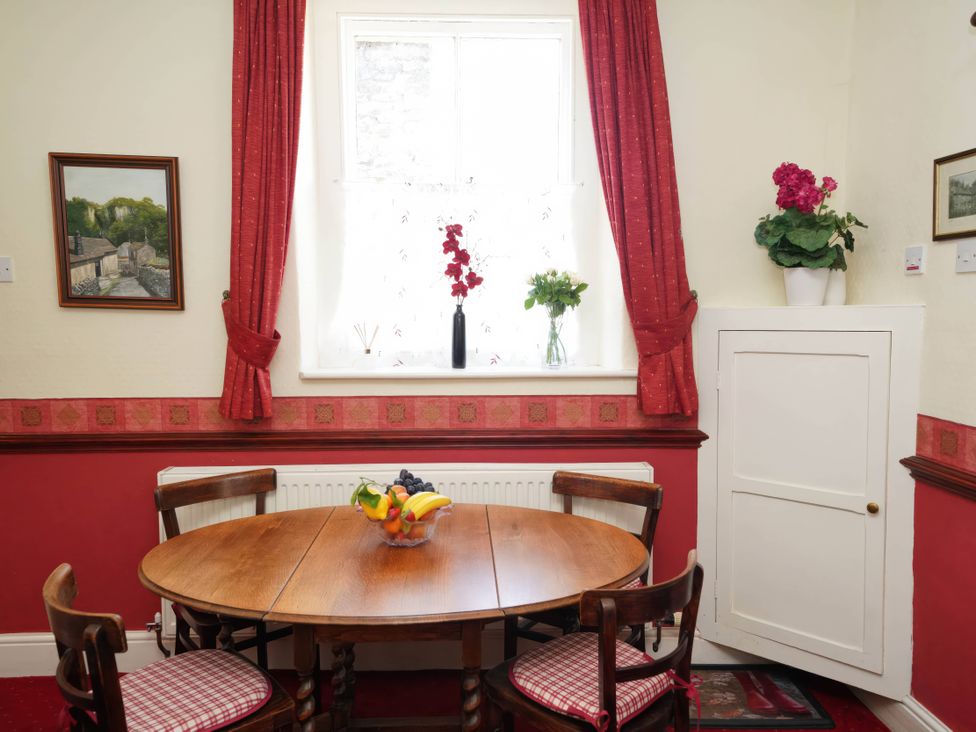 A dining room with a round table and chairs at Traditional 2 Bedroom Cottage in Eyam, Hope Valley