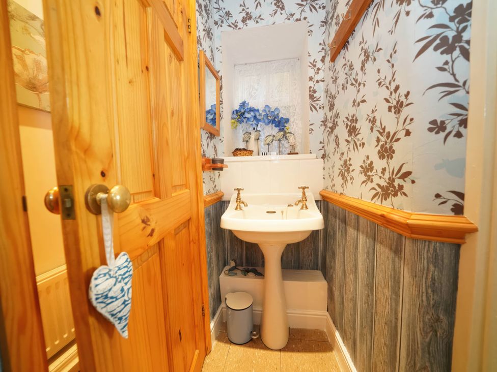 A bathroom with a sink and decorative flowers at Traditional 2 Bedroom Cottage in Eyam, Hope Valley
