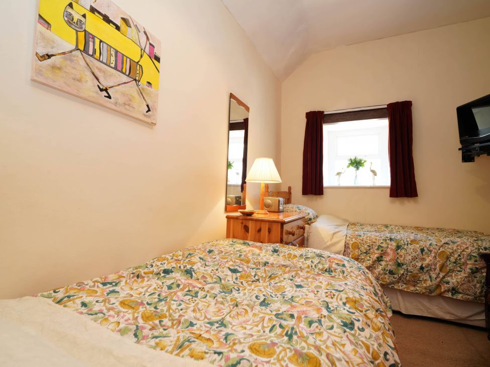 A bedroom with two beds and a table at Traditional 2 Bedroom Cottage in Eyam, Hope Valley