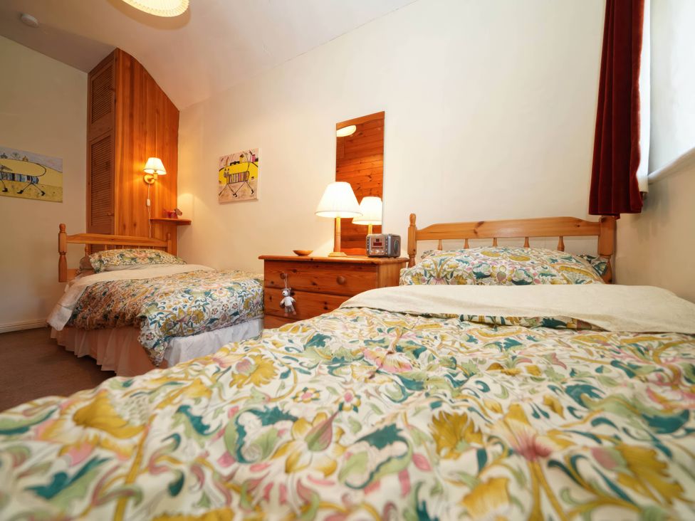 A bedroom with two beds and wooden furniture at Traditional 2 Bedroom Cottage in Eyam, Hope Valley