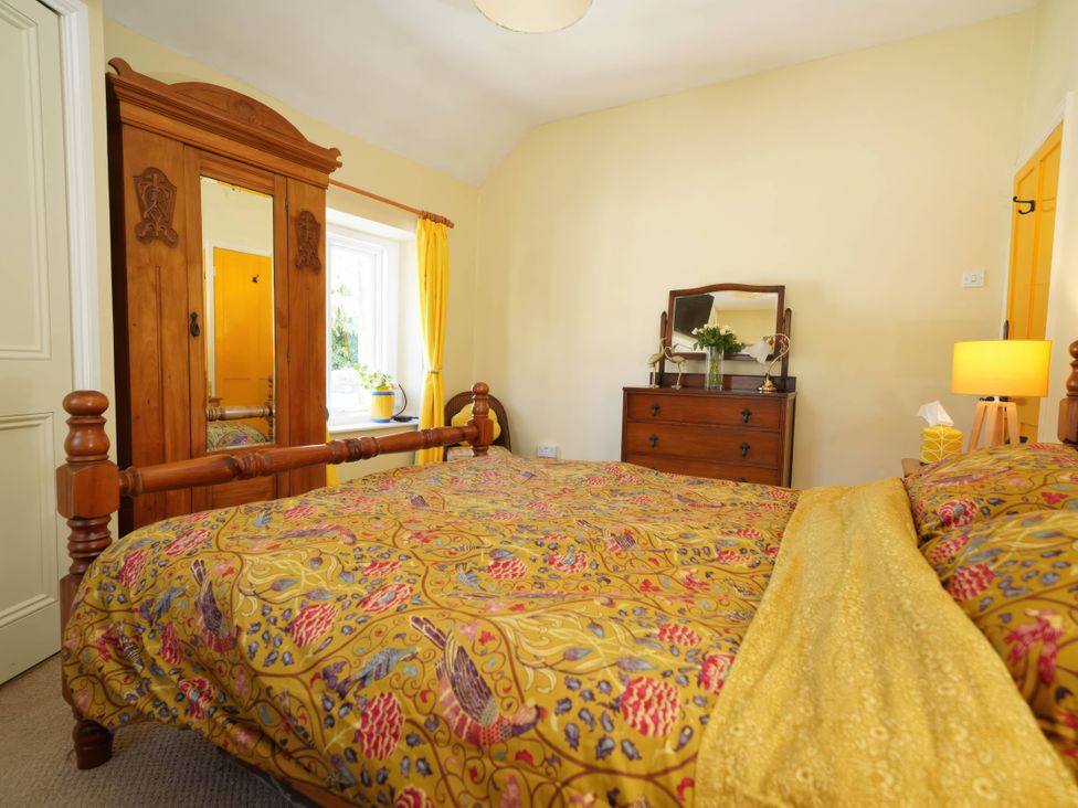 A bedroom with a bed and wardrobe at Traditional 2 Bedroom Cottage in Eyam, Hope Valley