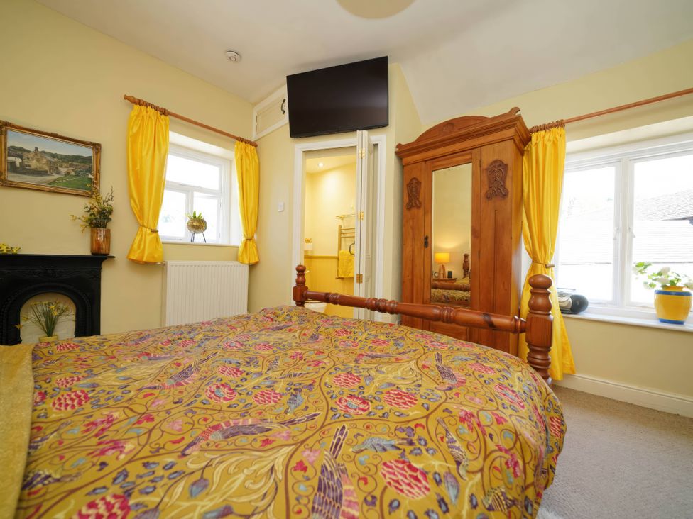 A bedroom with a bed and wardrobe in Traditional 2 Bedroom Cottage in Eyam, Hope Valley