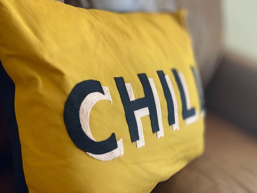 A pillow with the word CHILL in black and white on a yellow background