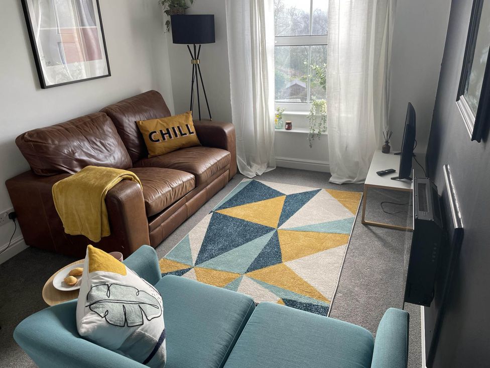 A living room with a sofa and rug at 2-Bed Flat in Summerbridge Harrogate, Pet Friendly 