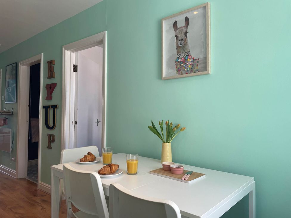 A dining room with a table and chairs, croissants and juice at 2-Bed Flat in Summerbridge Harrogate, Pet Friendly