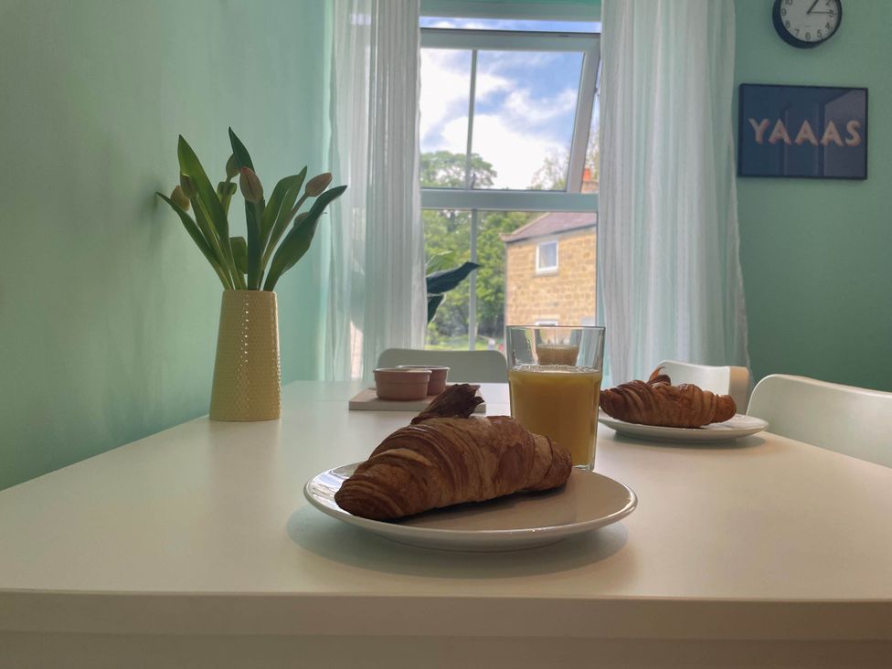 A dining room with croissants and juice on a table at 2-Bed Flat in Summerbridge Harrogate, Pet Friendly