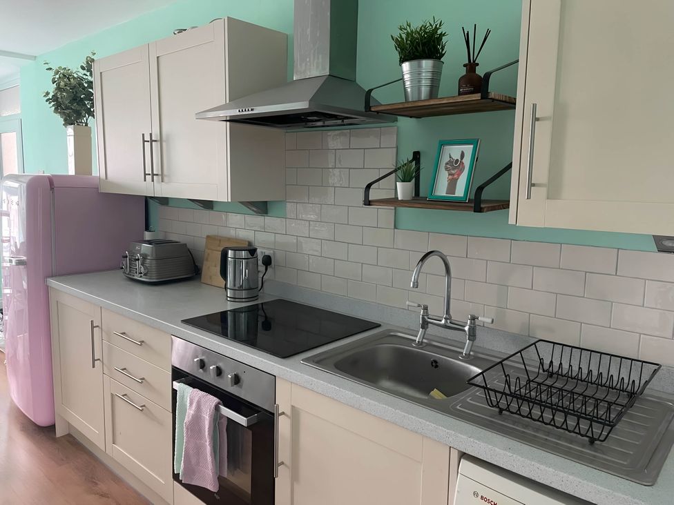 A kitchen with a pink refrigerator and white cabinets at 2-Bed Flat in Summerbridge Harrogate, Pet Friendly