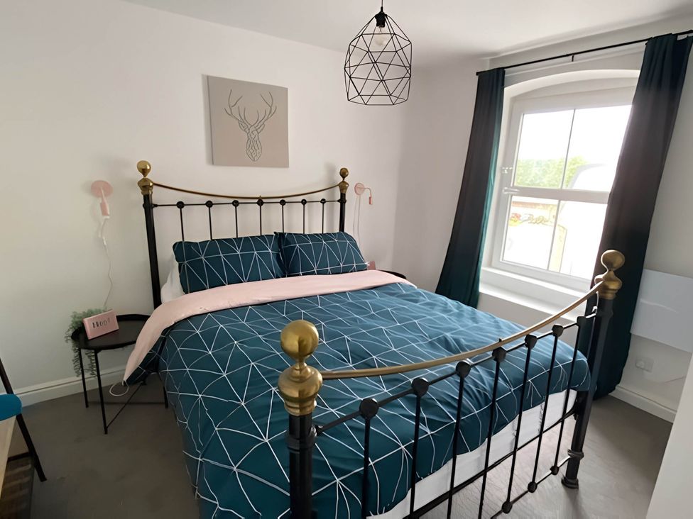 A bedroom with a bed and bedside lamp at 2-Bed Flat in Summerbridge Harrogate, Pet Friendly