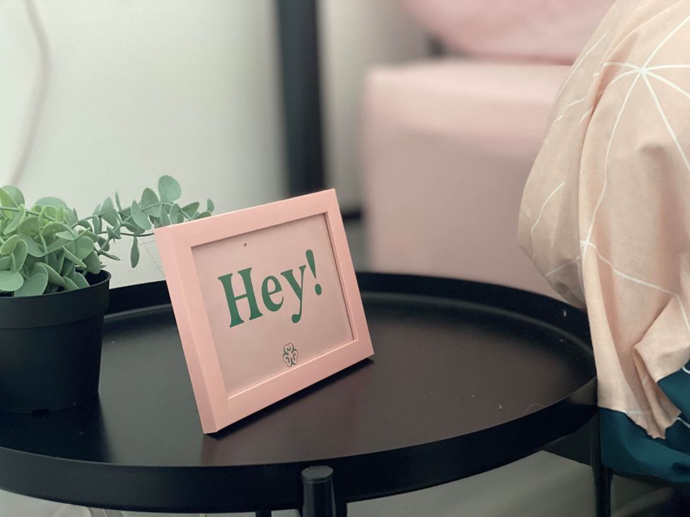 A table with a plant and photo frame in a bedroom at 2-Bed Flat in Summerbridge Harrogate, Pet Friendly 
