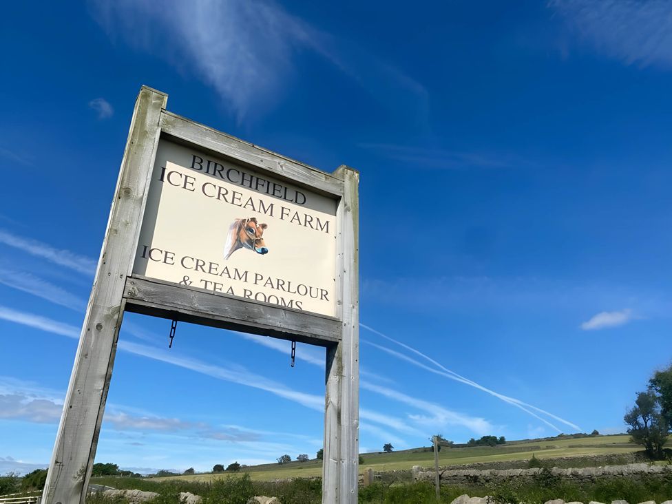 A sign for Birchfield Ice Cream Farm with blue sky in the background