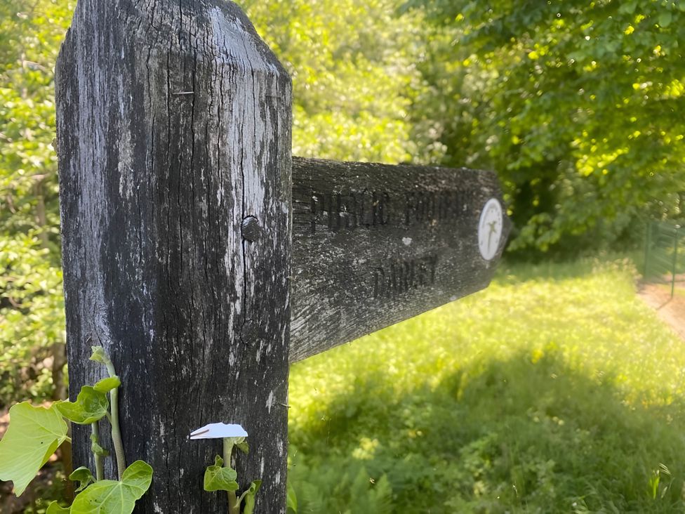 A wooden signpost in a green area at 2-Bed Flat in Summerbridge Harrogate, Pet Friendly