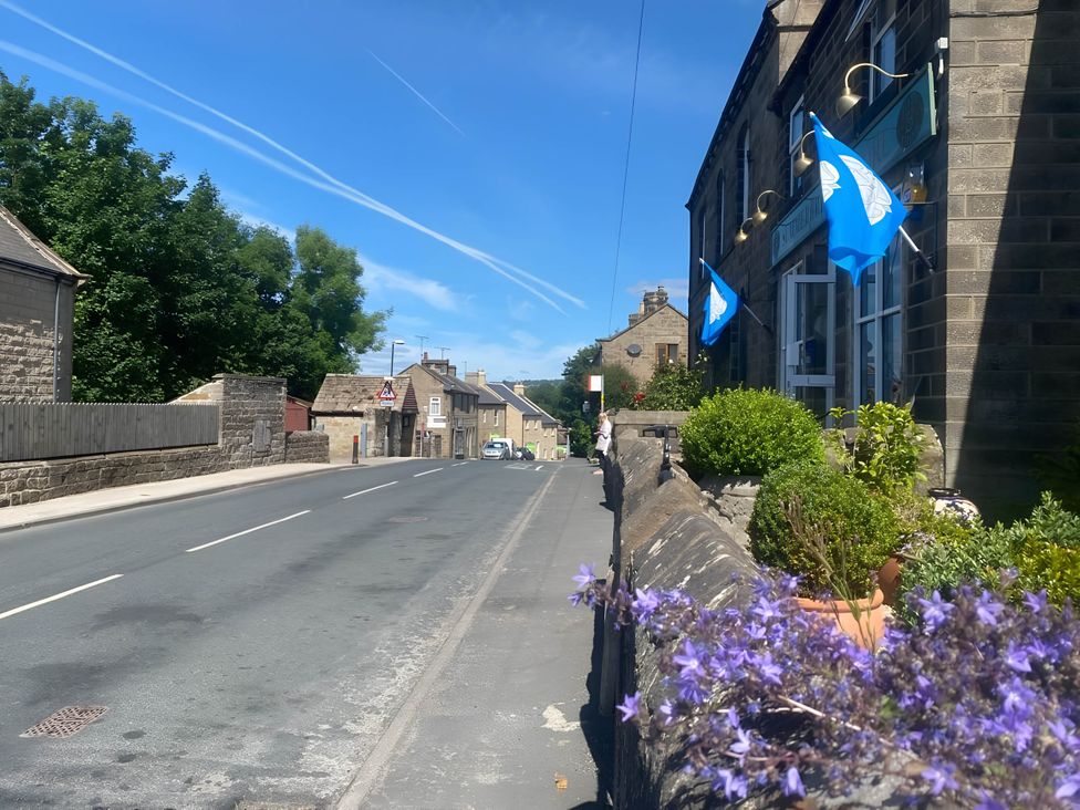 An outdoor view of a street with houses and potted plants at 2-Bed Flat in Summerbridge Harrogate