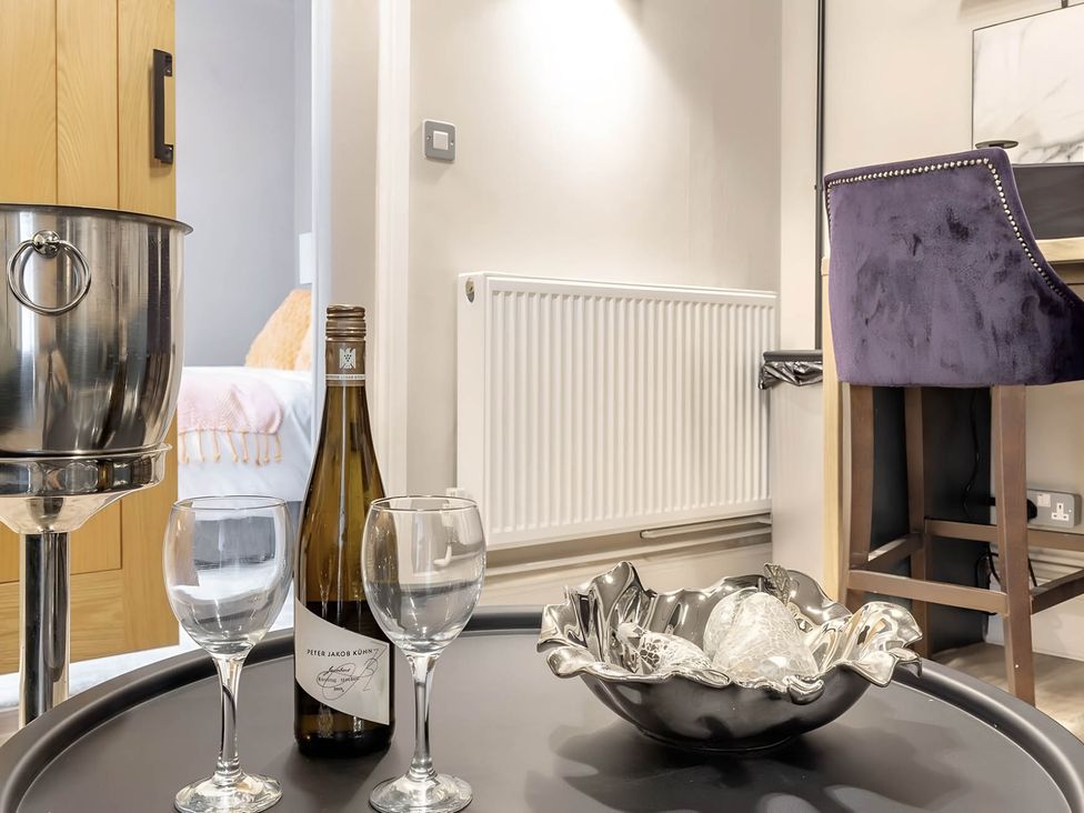 A living room with a wine bottle and glasses on a table at CentralEllesmere - Sleeps4 - Parking - PetFriendly