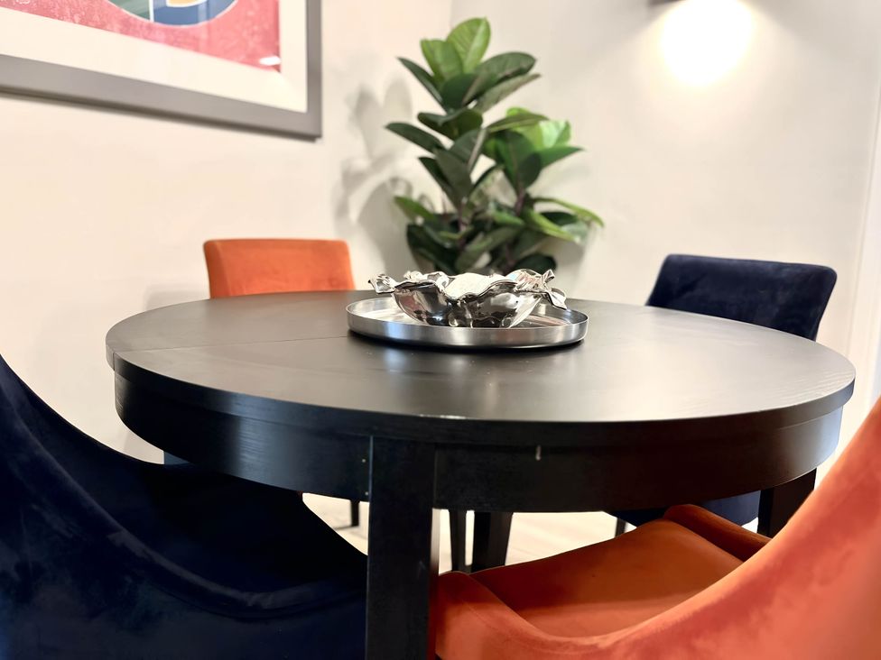 A dining room with a round table and colorful chairs at CentralEllesmere - Sleeps4 - Parking - PetFriendly