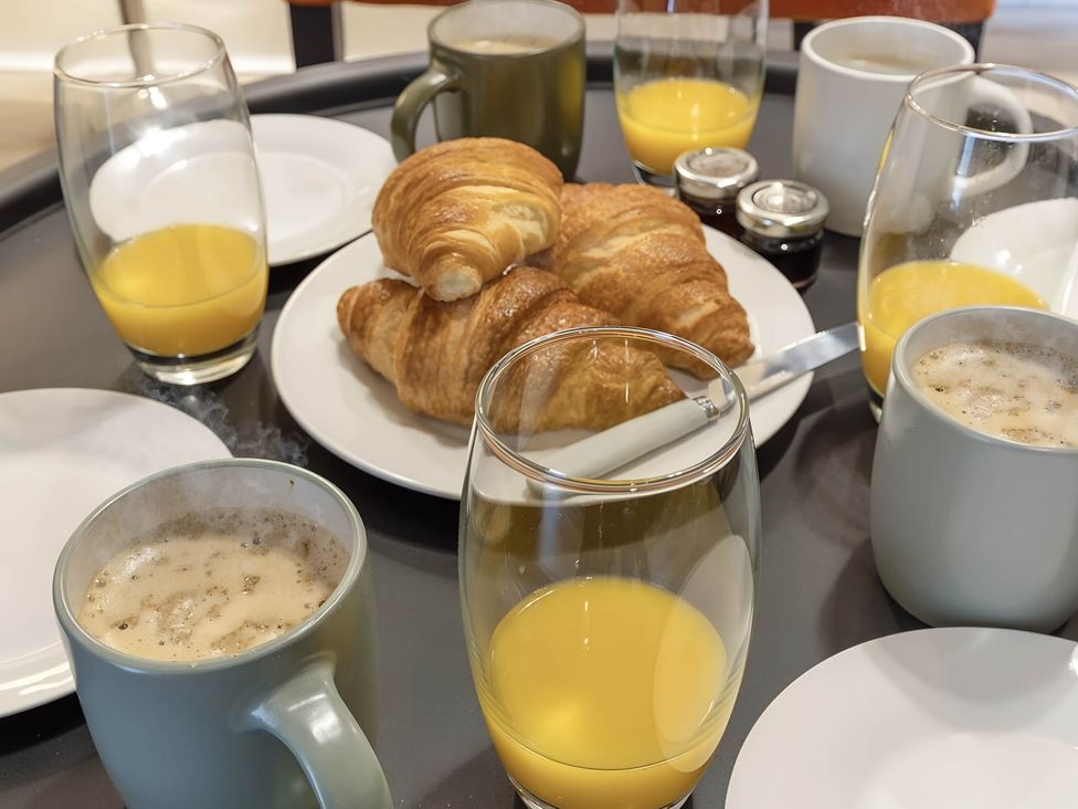 A breakfast setup with croissants, coffee, and orange juice in CentralEllesmere - Sleeps4 - Parking - PetFriendly