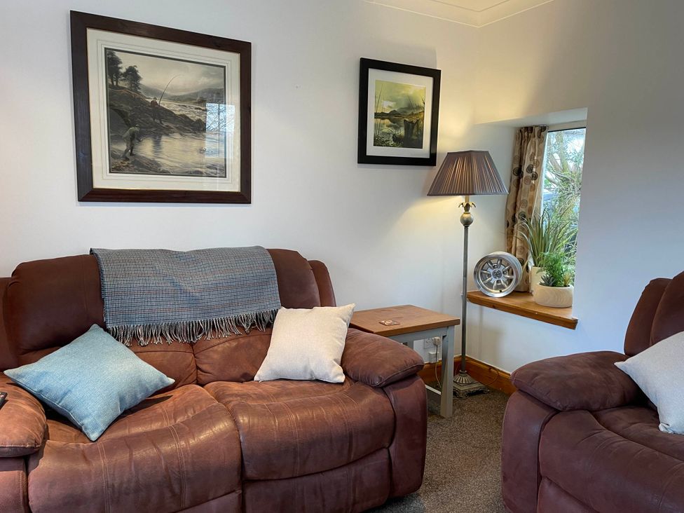 A living room with sofas and a lamp at 1 Keepers Cottage, Skeabost Bridge, Isle Of Skye