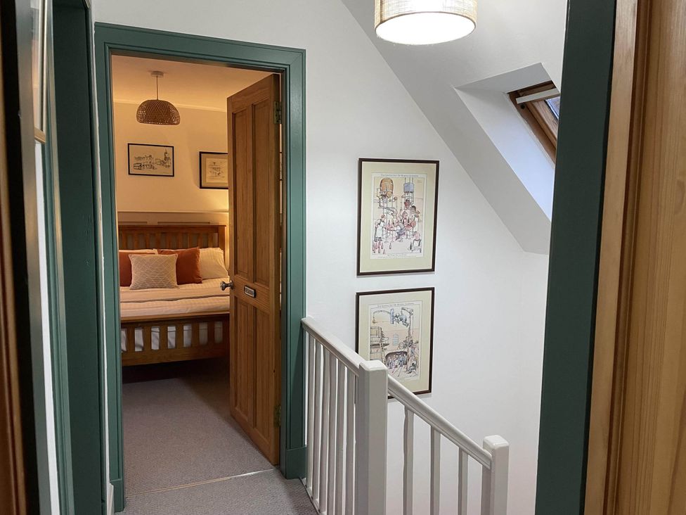 A hallway with a door leading to a bedroom at 1 Keepers Cottage, Skeabost Bridge, Isle Of Skye