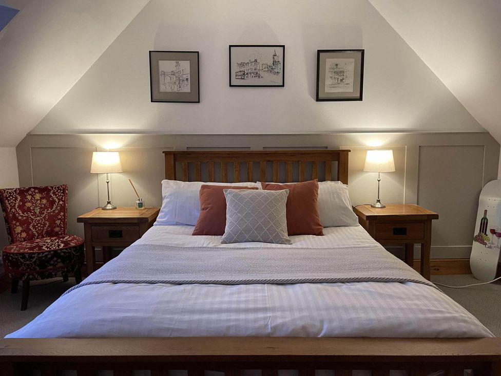 A bedroom with a bed and nightstands at 1 Keepers Cottage, Skeabost Bridge, Isle Of Skye
