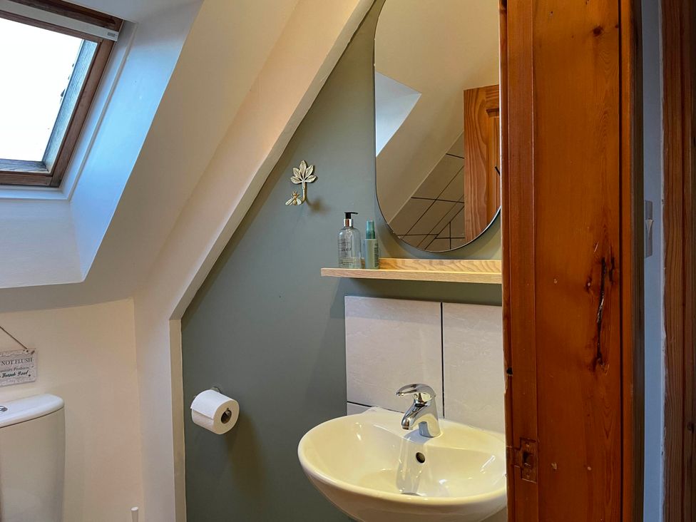 A bathroom with a sink, mirror, and toilet at 1 Keepers Cottage, Skeabost Bridge, Isle Of Skye