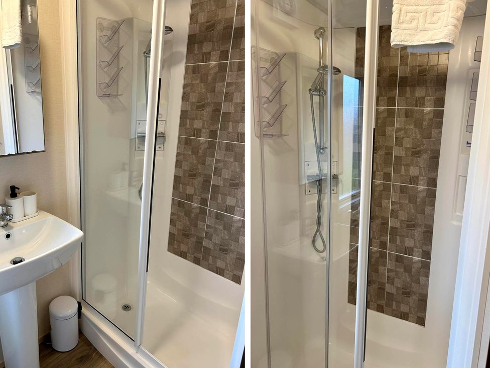 A bathroom with a shower and sink at Static Caravan Hoburne Devon Bay